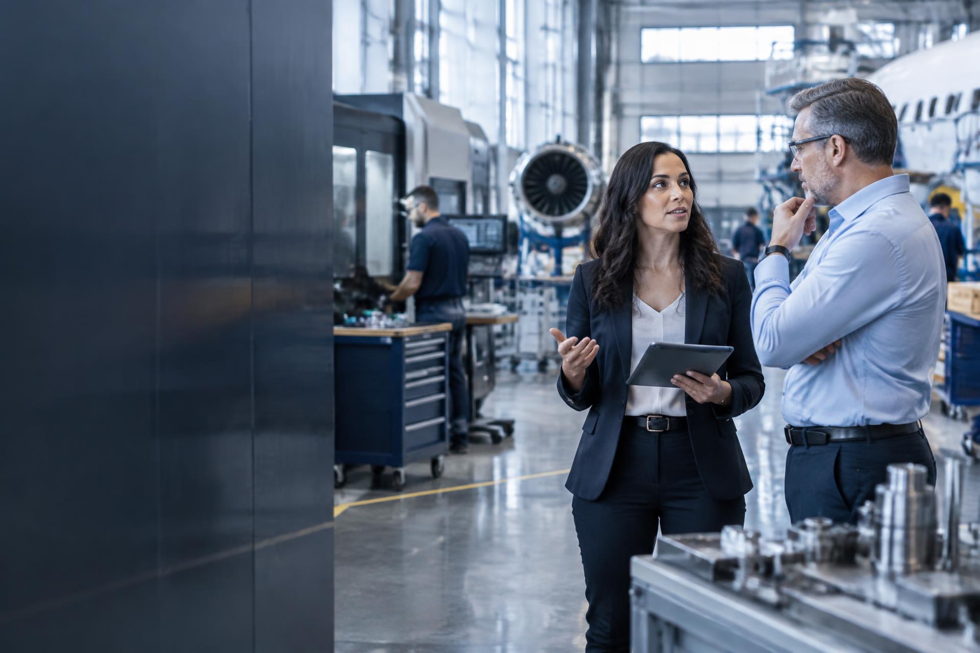 Compliance professionals collaborating in an aerospace manufacturing facility